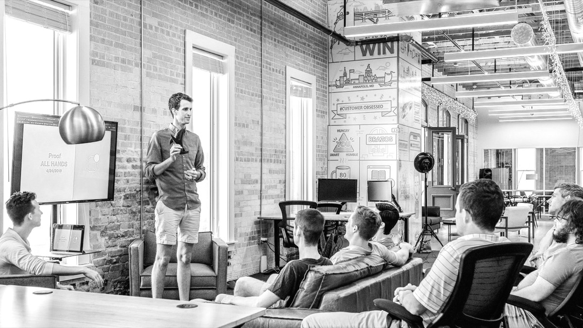 A facilitator presenting to a seated team in a loft space